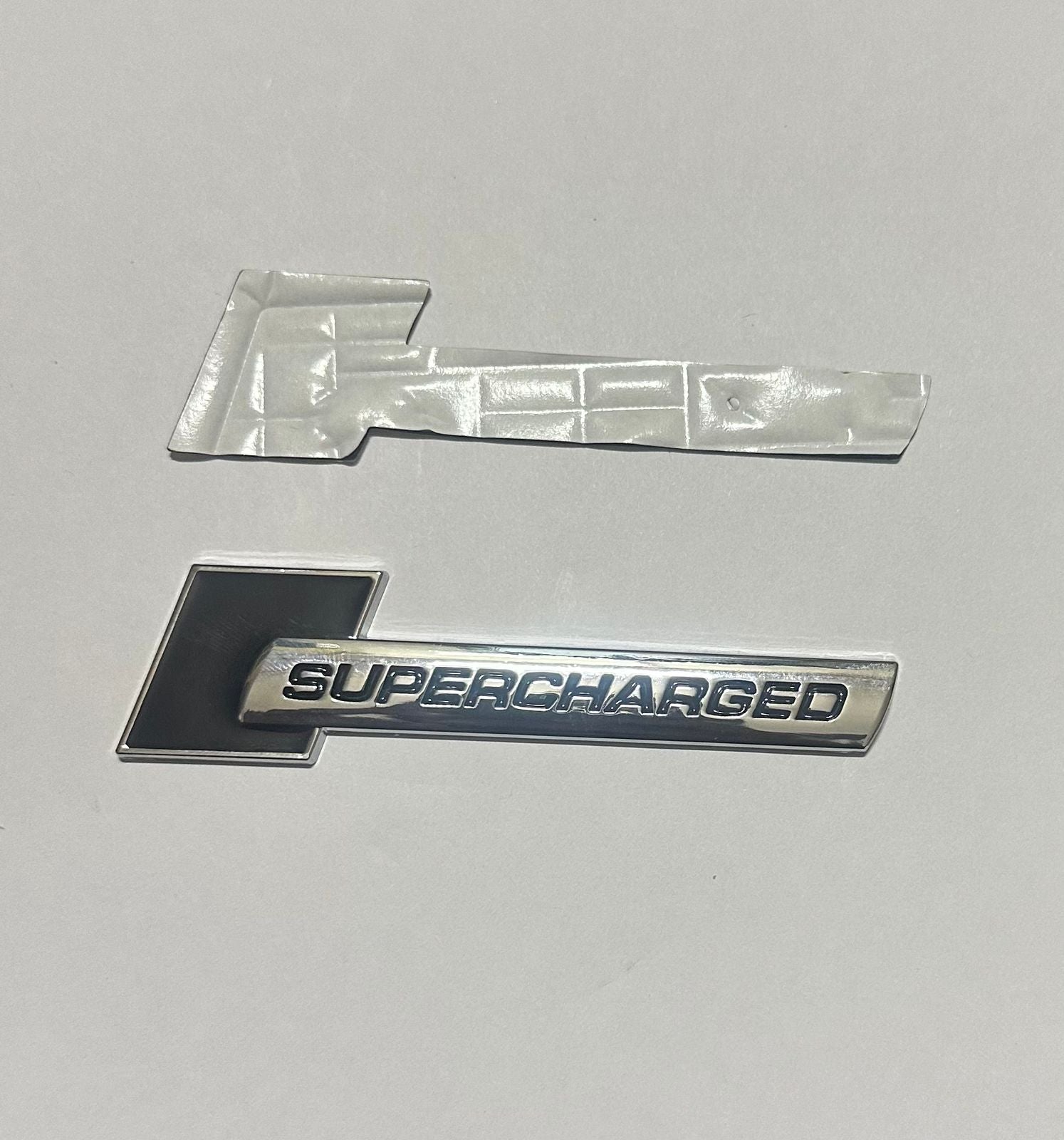 Supercharged (1PC) Logo Chrome Black. 10 x 2.6cm Car Bike Metal Supercharged Logo Car Emblem Premium 3D Badge Auto Racing Sport Sticker Grand Tourer Decal